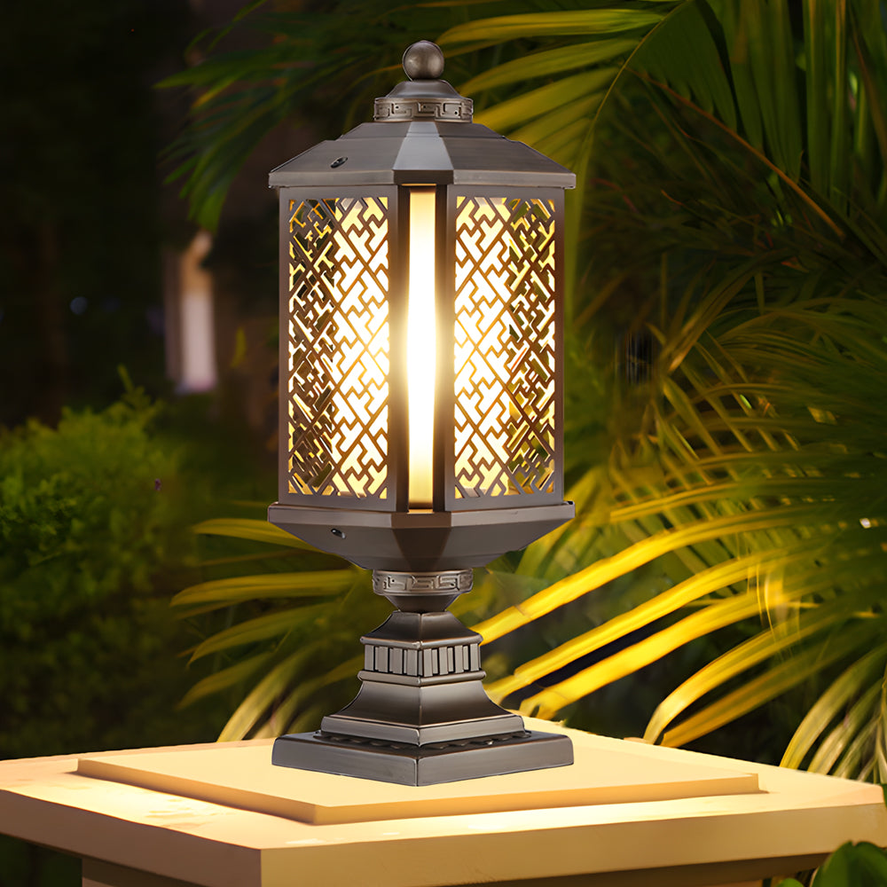 Modern outdoor pillar lights with intricate designs, providing warm illumination in a garden.