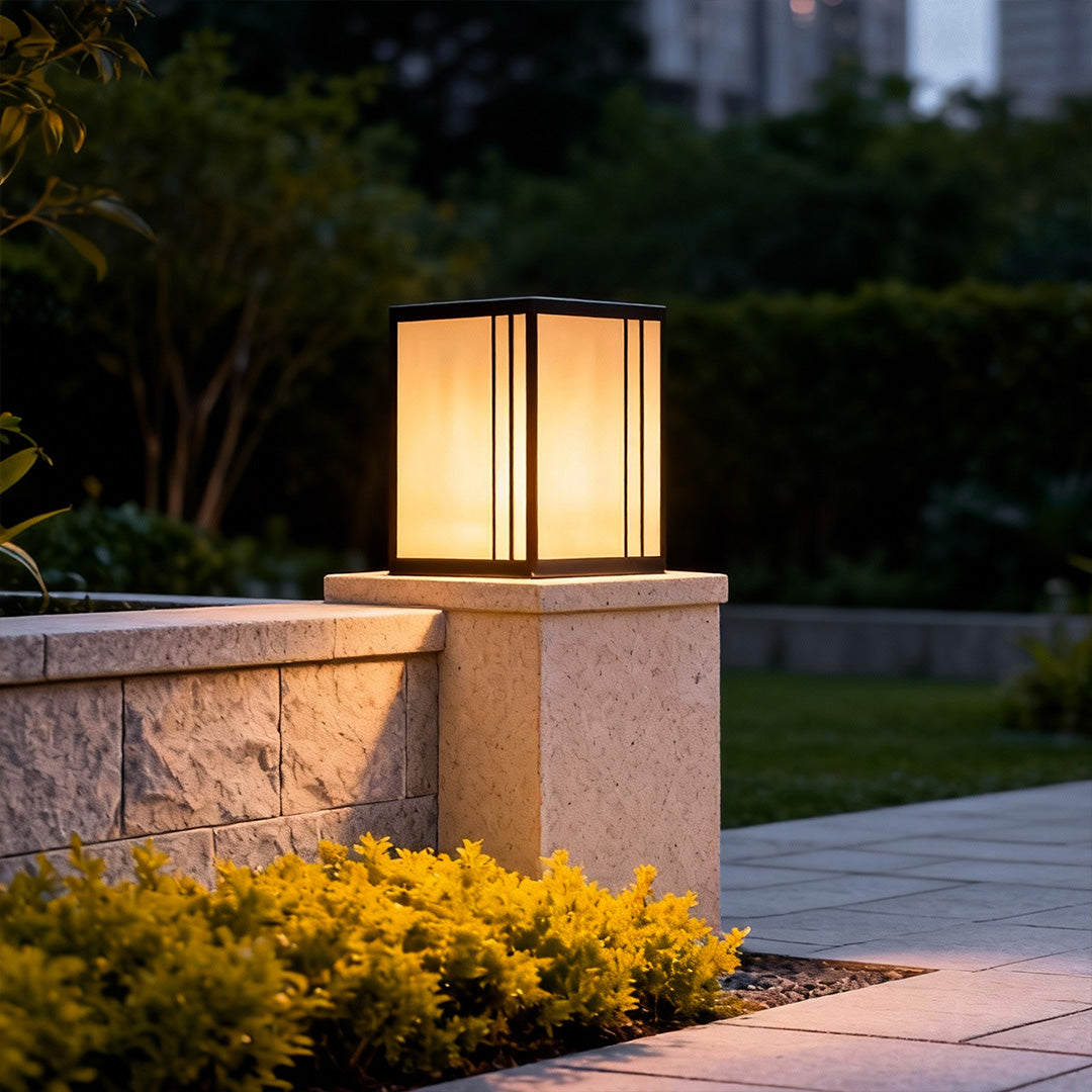 Modern outdoor pillar lights LED illuminating a stone pillar in a garden pathway at dusk.