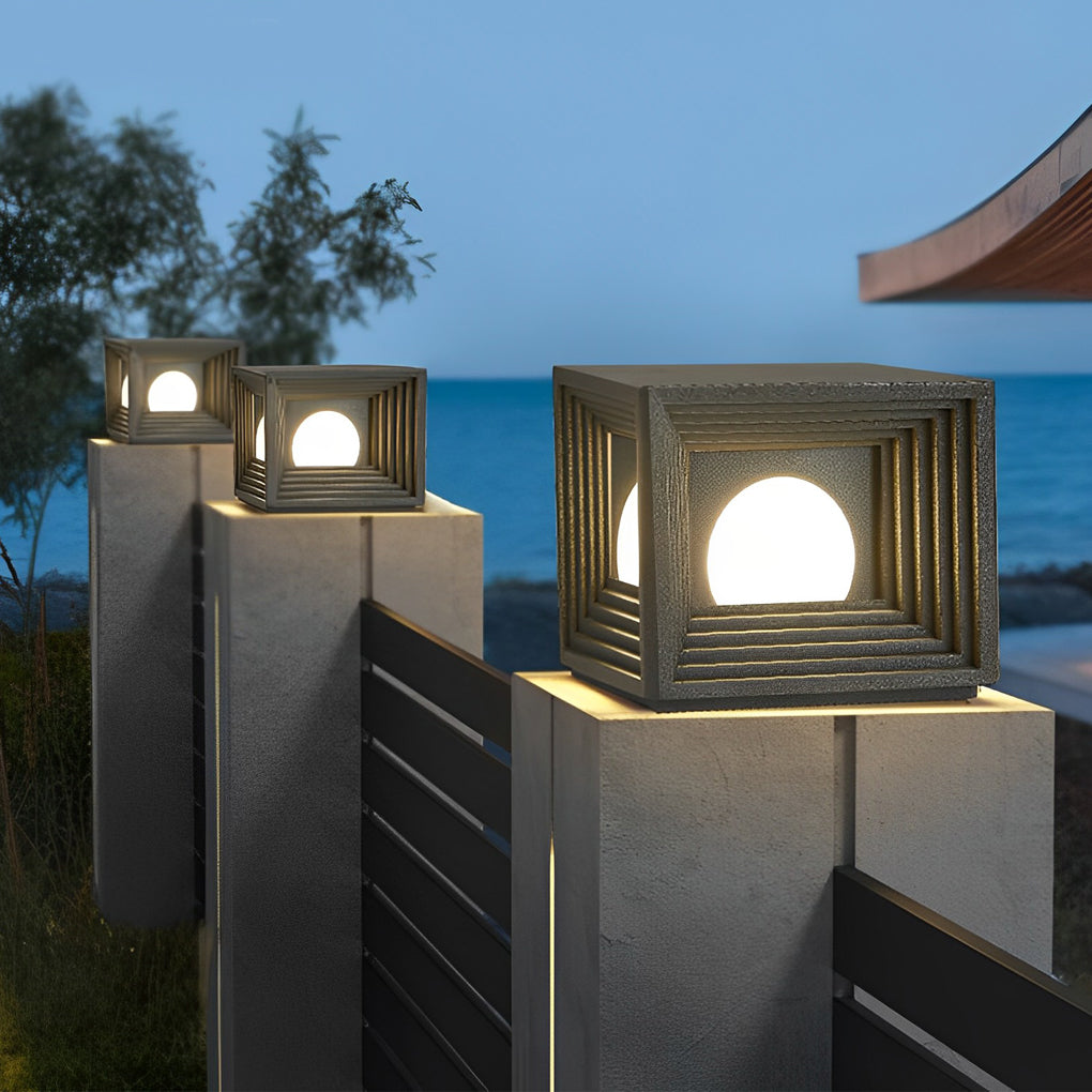 Modern outdoor pillar lights with a minimalist design, providing warm light near a waterfront.