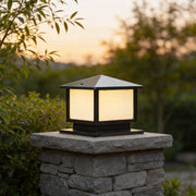 Modern outdoor pillar lights mounted on a stone column, featuring a square black frame and soft warm glow for garden entrances.