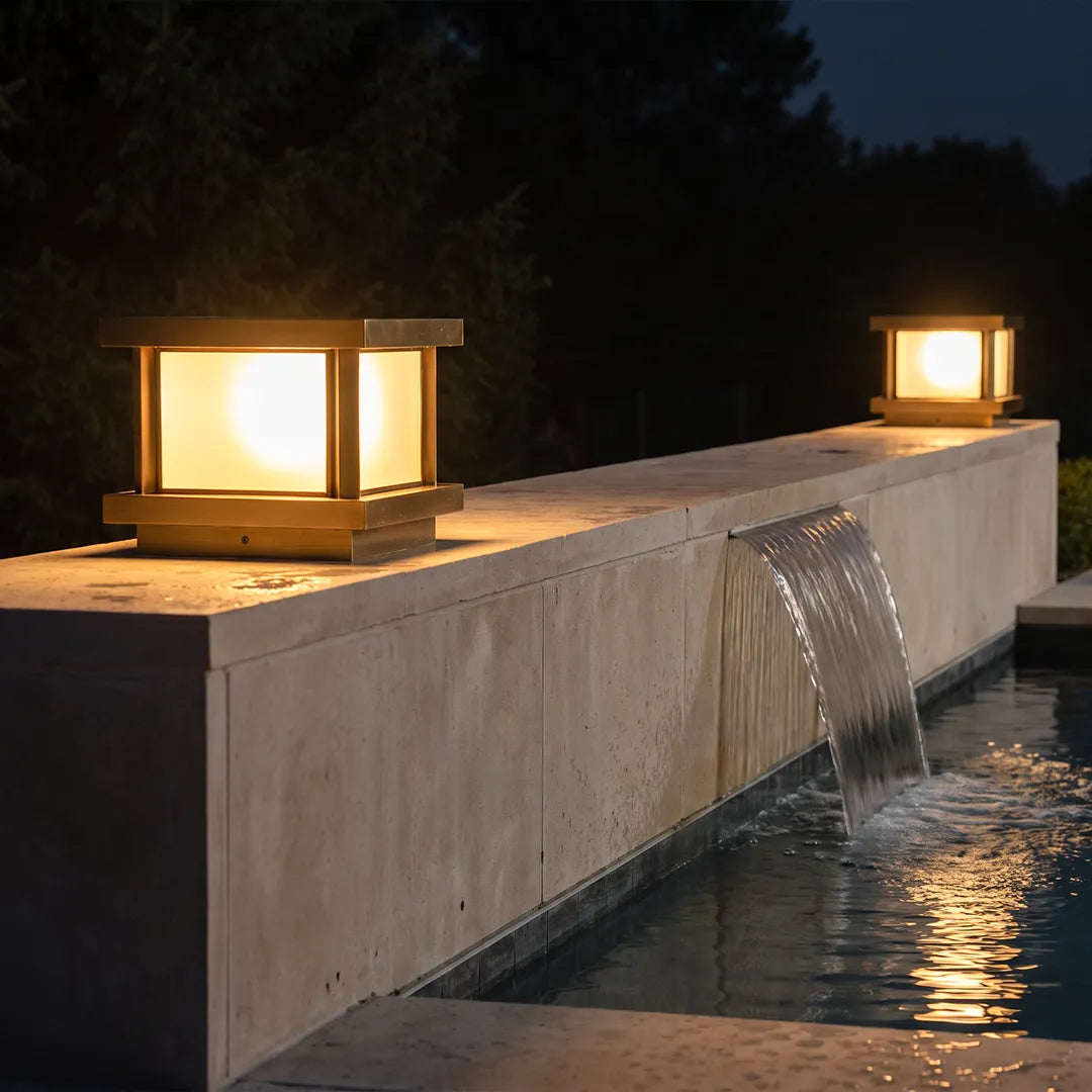 Modern outdoor pillar lights illuminating stone wall and outdoor water feature