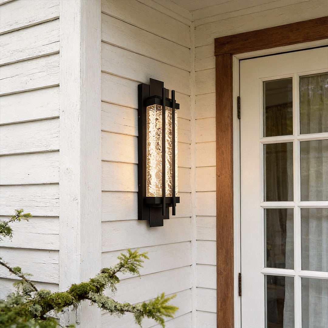Modern outdoor sconce lighting with a rectangular design, mounted beside a white wooden door.