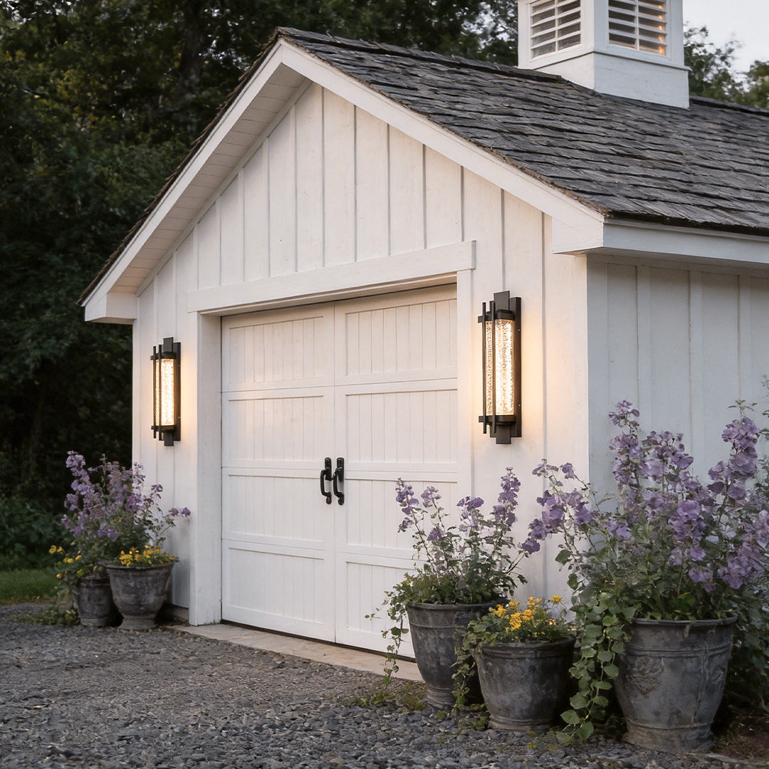 Modern outdoor sconce lighting with a sleek design, enhancing a white garage exterior.
