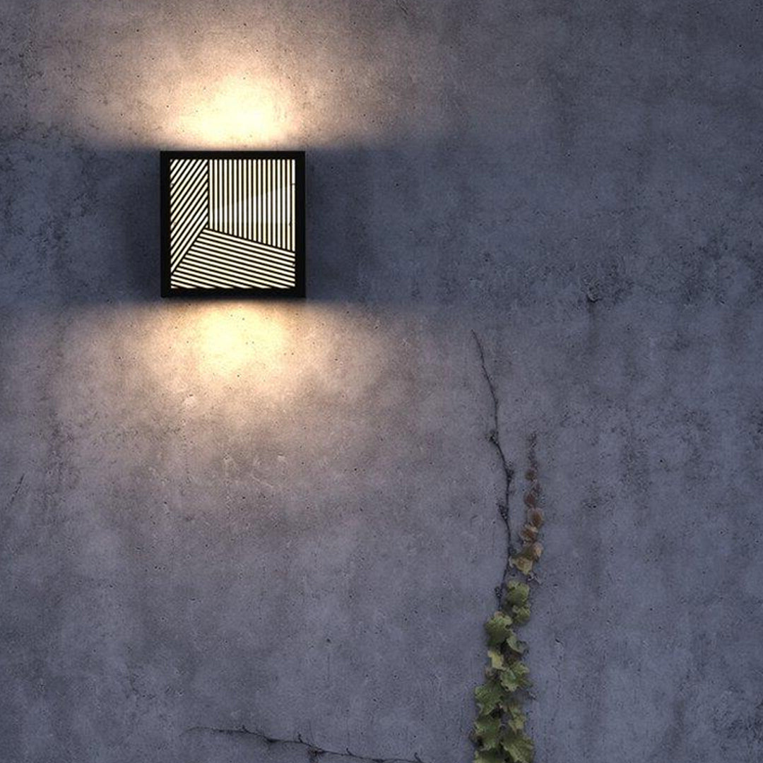 Warm outdoor evening setting illuminated by modern outdoor sconces black featuring a bold artistic grille design.
