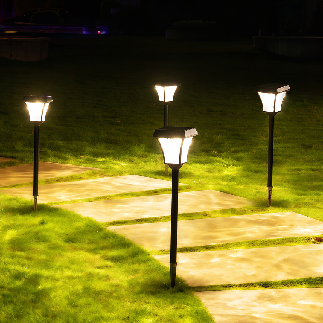 Modern outdoor solar path lighting illuminating a stone stepping-stone walkway in a yard at night.