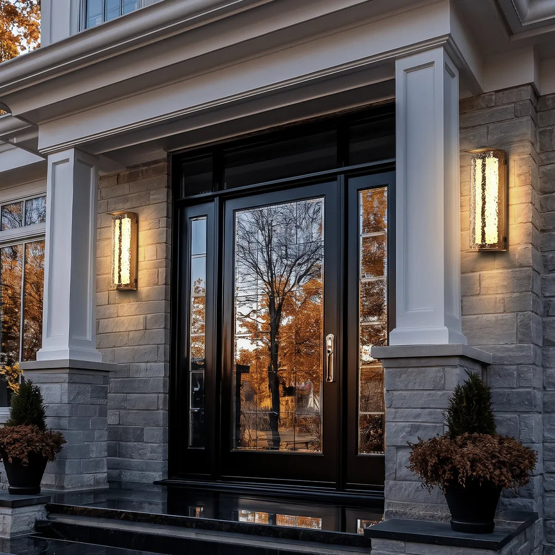 Modern outdoor solar wall lights flanking a front door on a grand stone entryway.