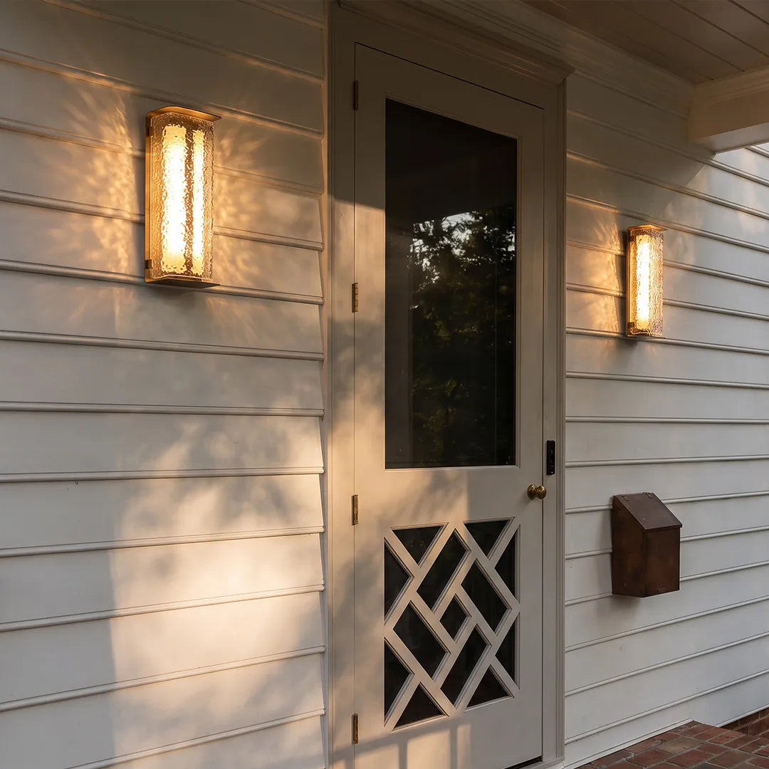 Modern outdoor solar wall lights installed beside a white entry door on horizontal siding.