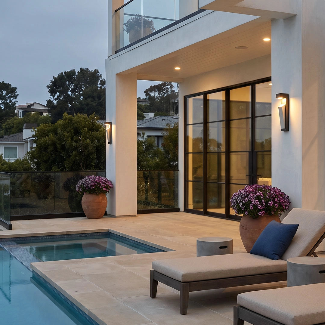 Modern outdoor wall light mounted beside a pool on a contemporary home exterior.