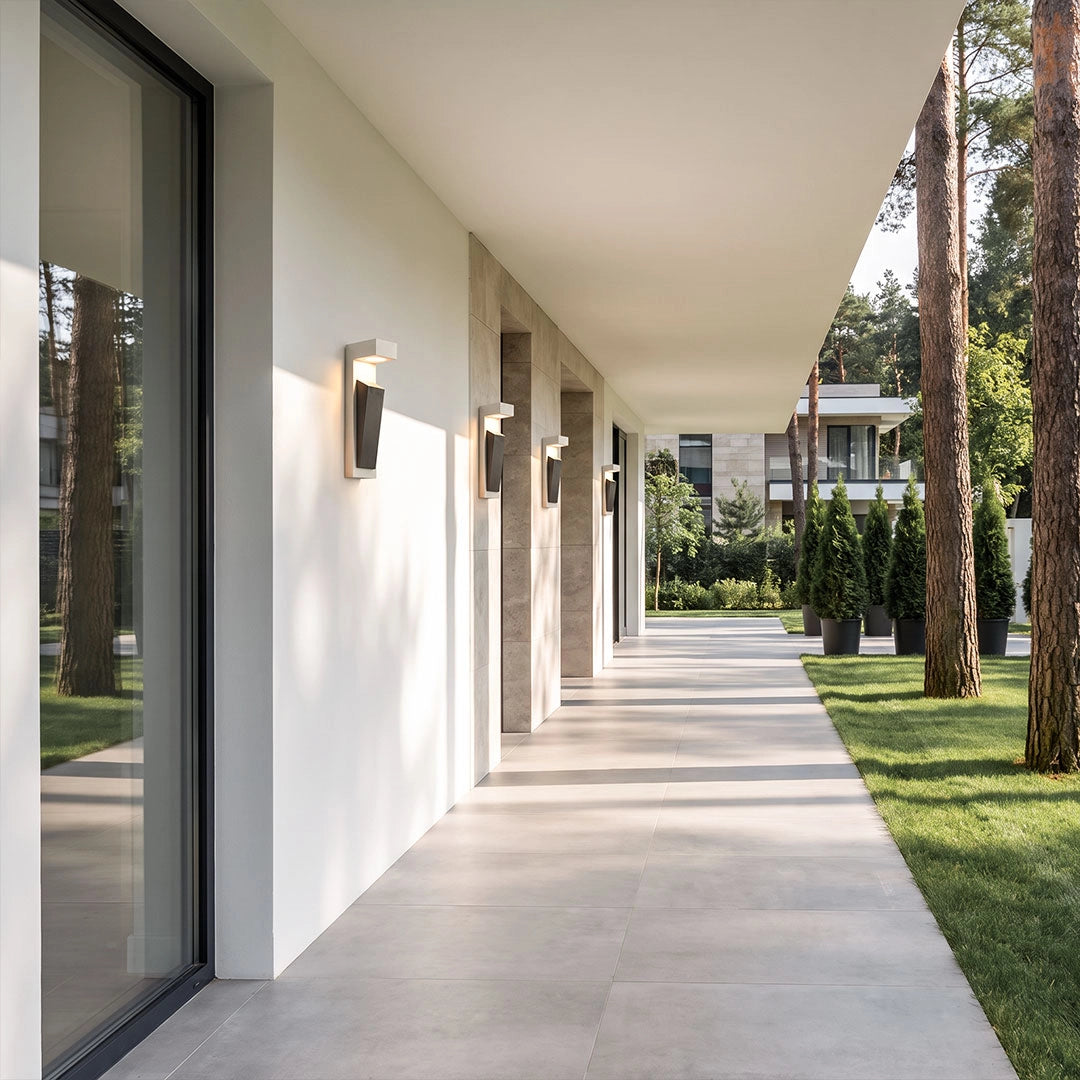 Modern outdoor wall light installed along a covered exterior hallway of a minimalist home.