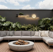 Modern outdoor wall lights with circular LED design mounted on a concrete garden wall daytime