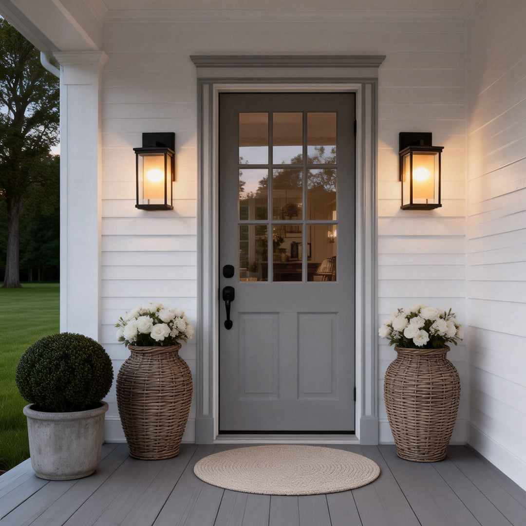 Modern outdoor wall mounted light enhancing the entrance of a white house with potted plants and cozy doormat.