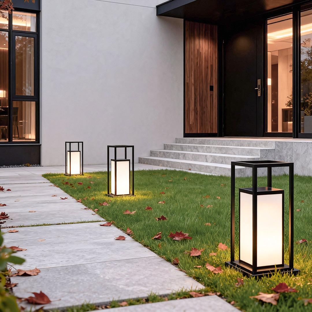 Modern outdoor wall pillar lights decorating front yard walkway near home entrance.