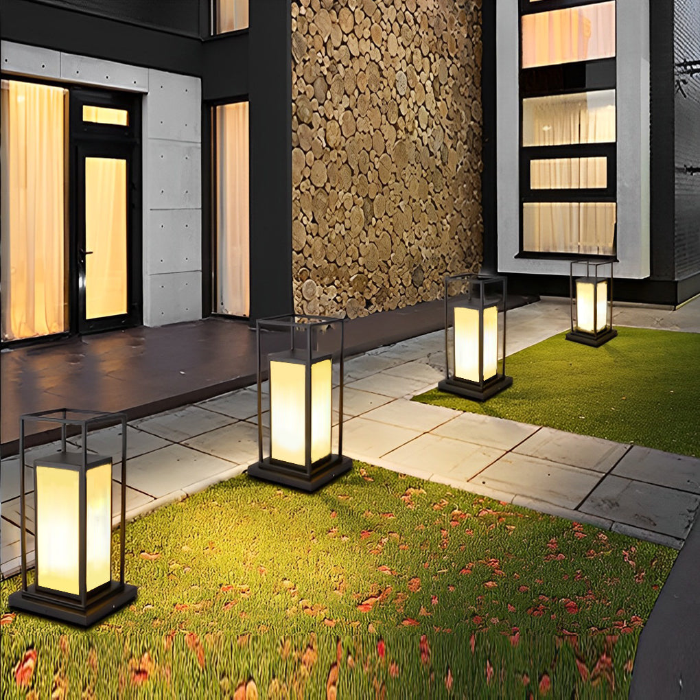 Modern outdoor wall pillar lights lining garden walkway near contemporary home exterior.