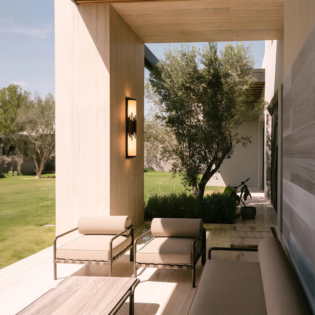 Modern outdoor wall sconce illuminating covered garden dining area