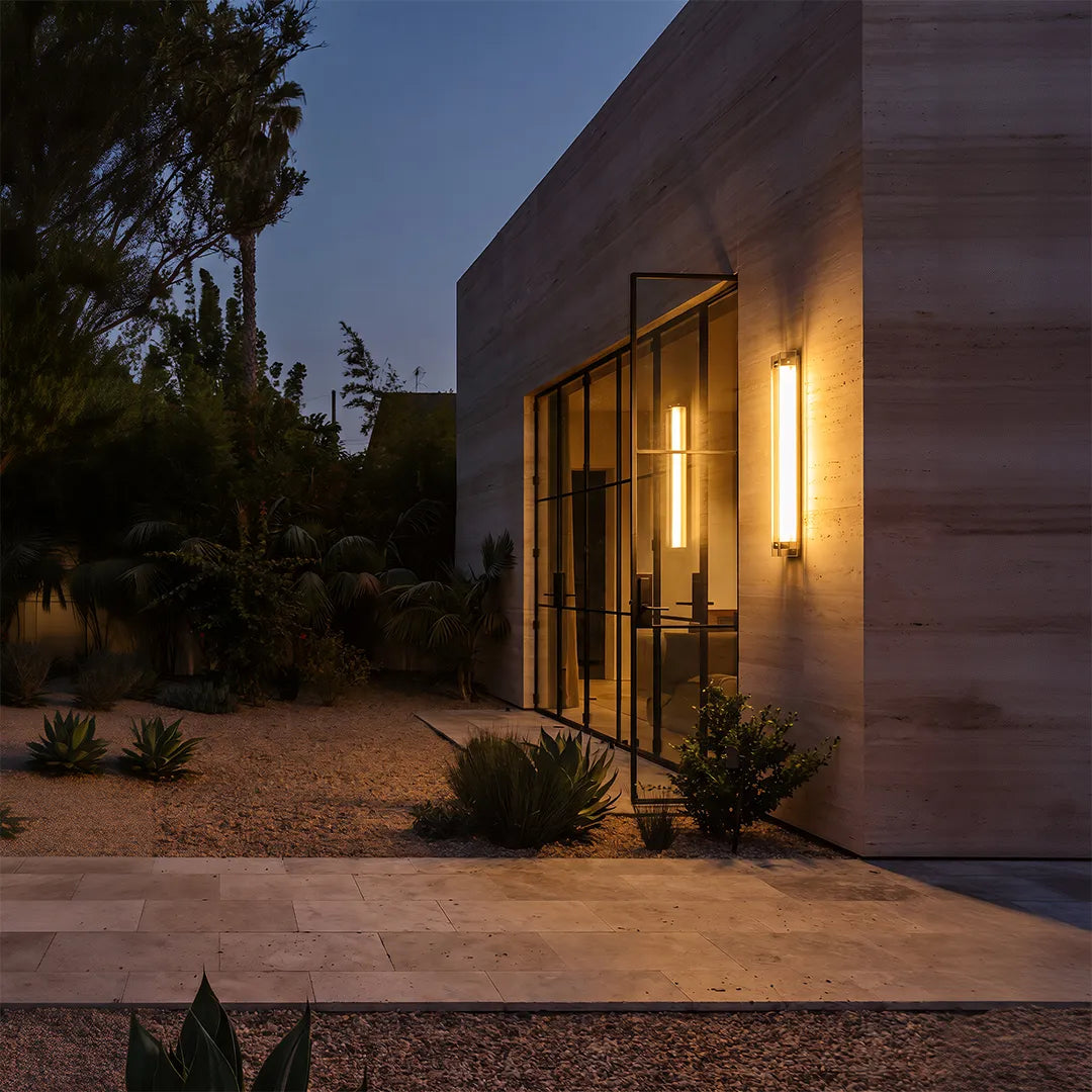 Modern outdoor wall sconce illuminating contemporary home patio at dusk