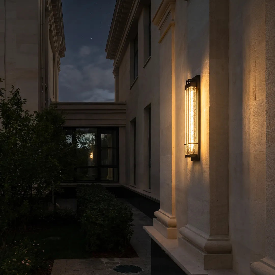 Modern outdoor wall sconce with warm glow along residential side yard