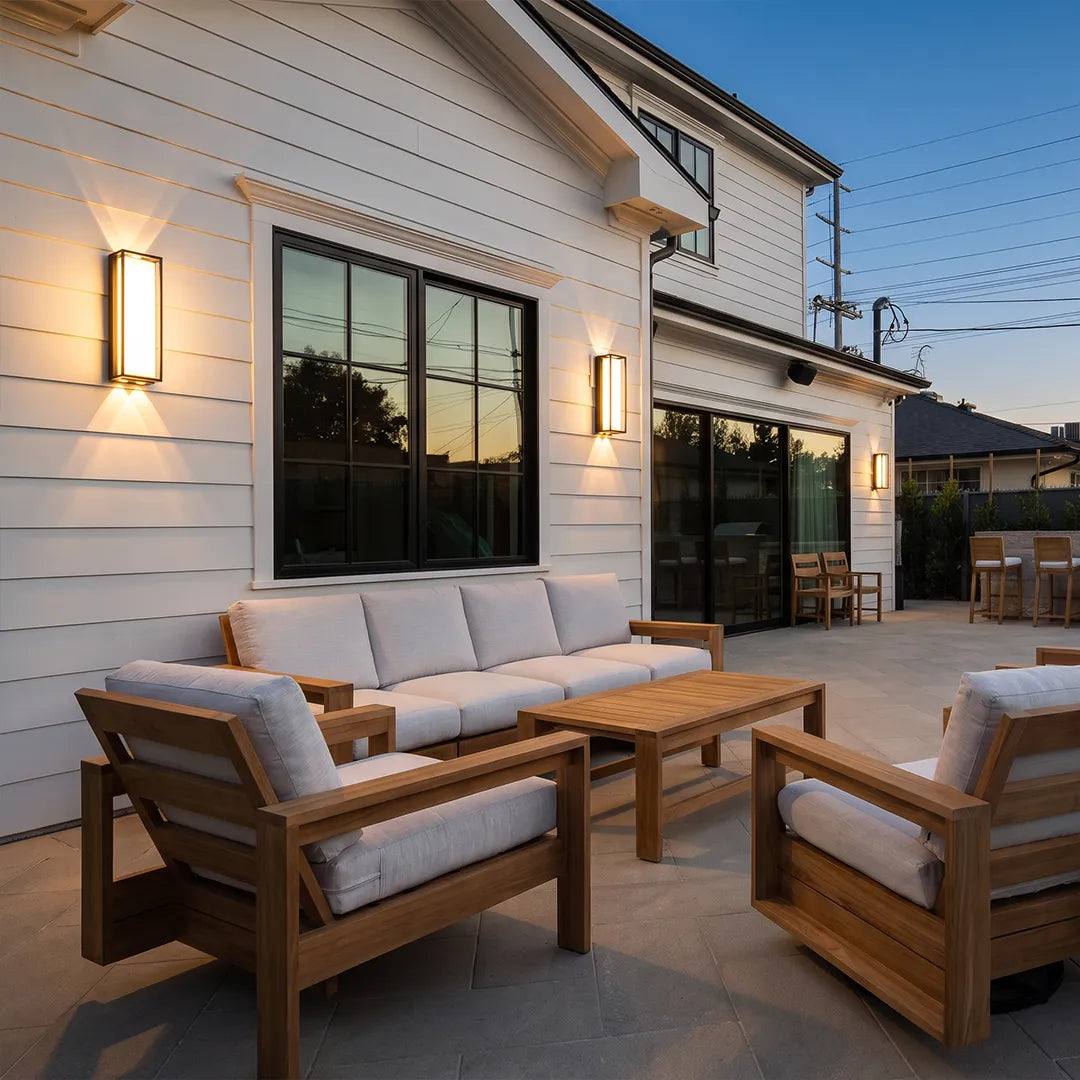 Modern outdoor wall sconces illuminating backyard patio and lounge seating