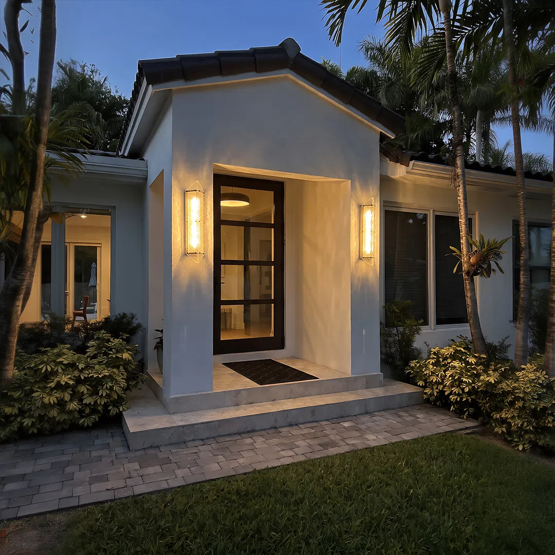 Modern outdoor wall sconces with warm lighting beside home entrance