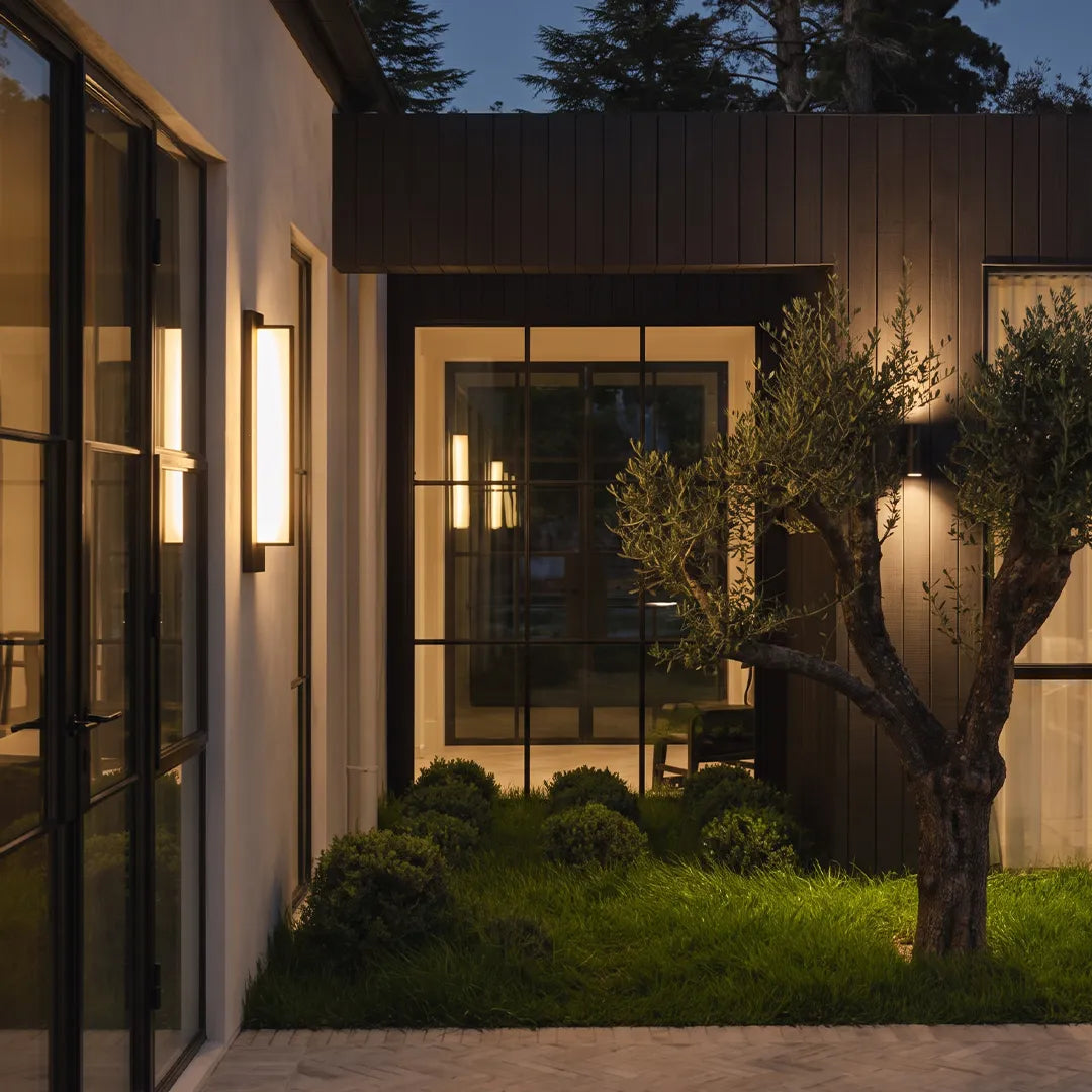 Modern outdoor wall sconces illuminating garden walkway and home entrance
