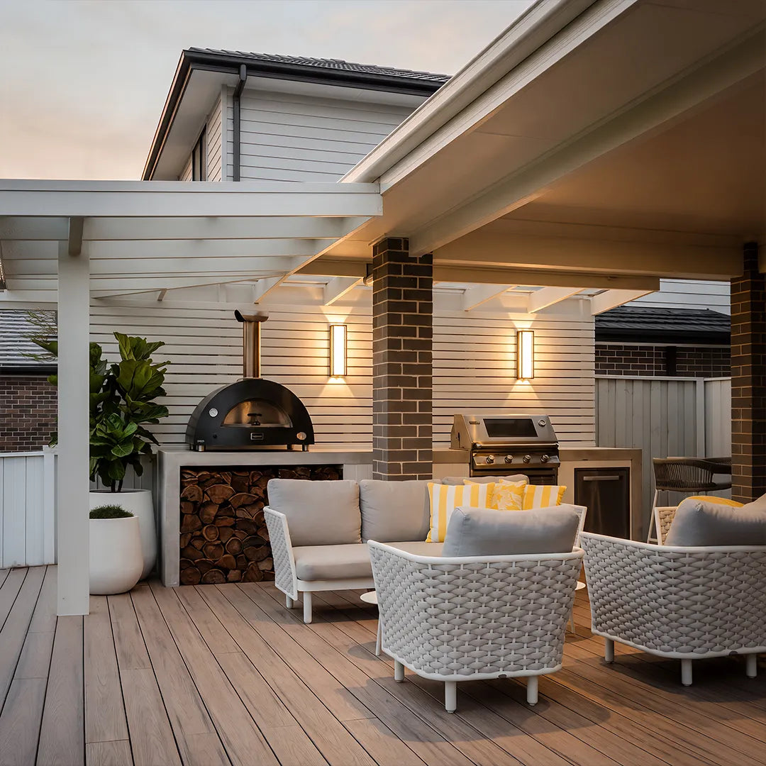 Modern outdoor wall sconces illuminating outdoor kitchen and patio lounge