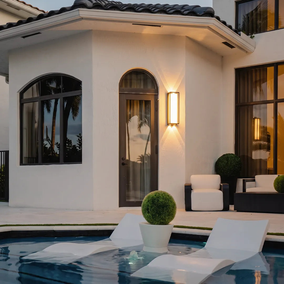 Modern outdoor wall sconces illuminating poolside patio and home exterior