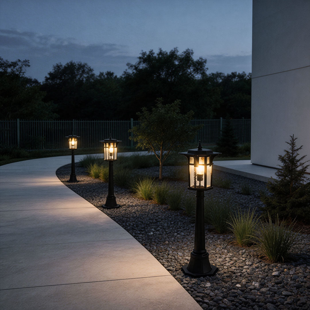 Modern path light illuminating a curved garden pathway with warm ambient glow at dusk.