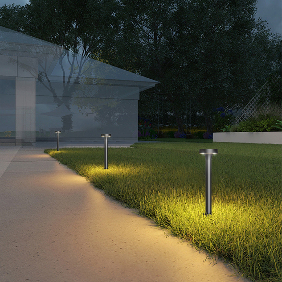 Modern pathway lighting installation featuring sleek bollards along concrete walkway at dusk