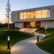 Modern residential pathway illuminated with sleek black Landscape Bollard Lights beside a curved concrete walkway at dusk.