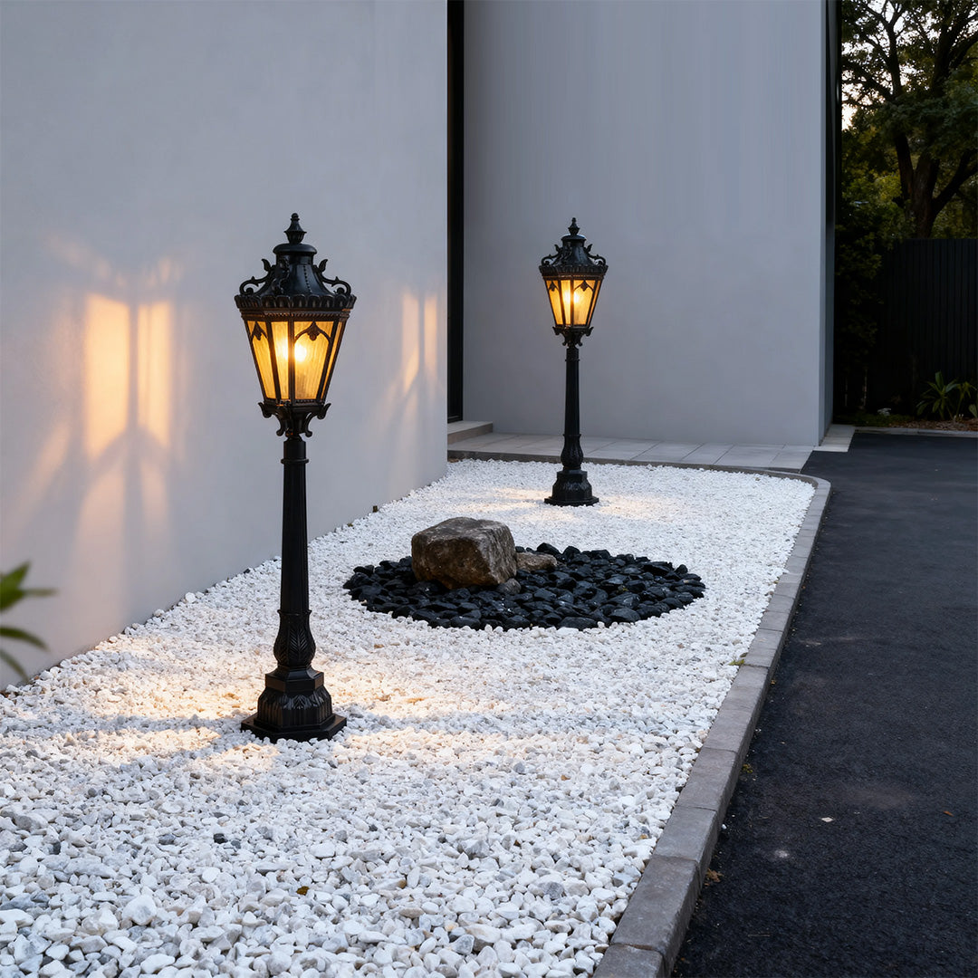 Modern pathway lighting bollards pair brightening white gravel landscaping in minimalist courtyard setting
