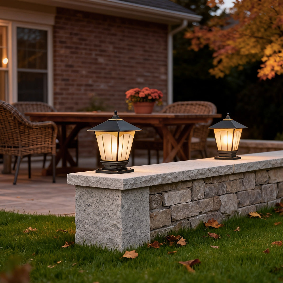 Modern pillar lights for house adding ambiance to a garden fence with warm, welcoming light.
