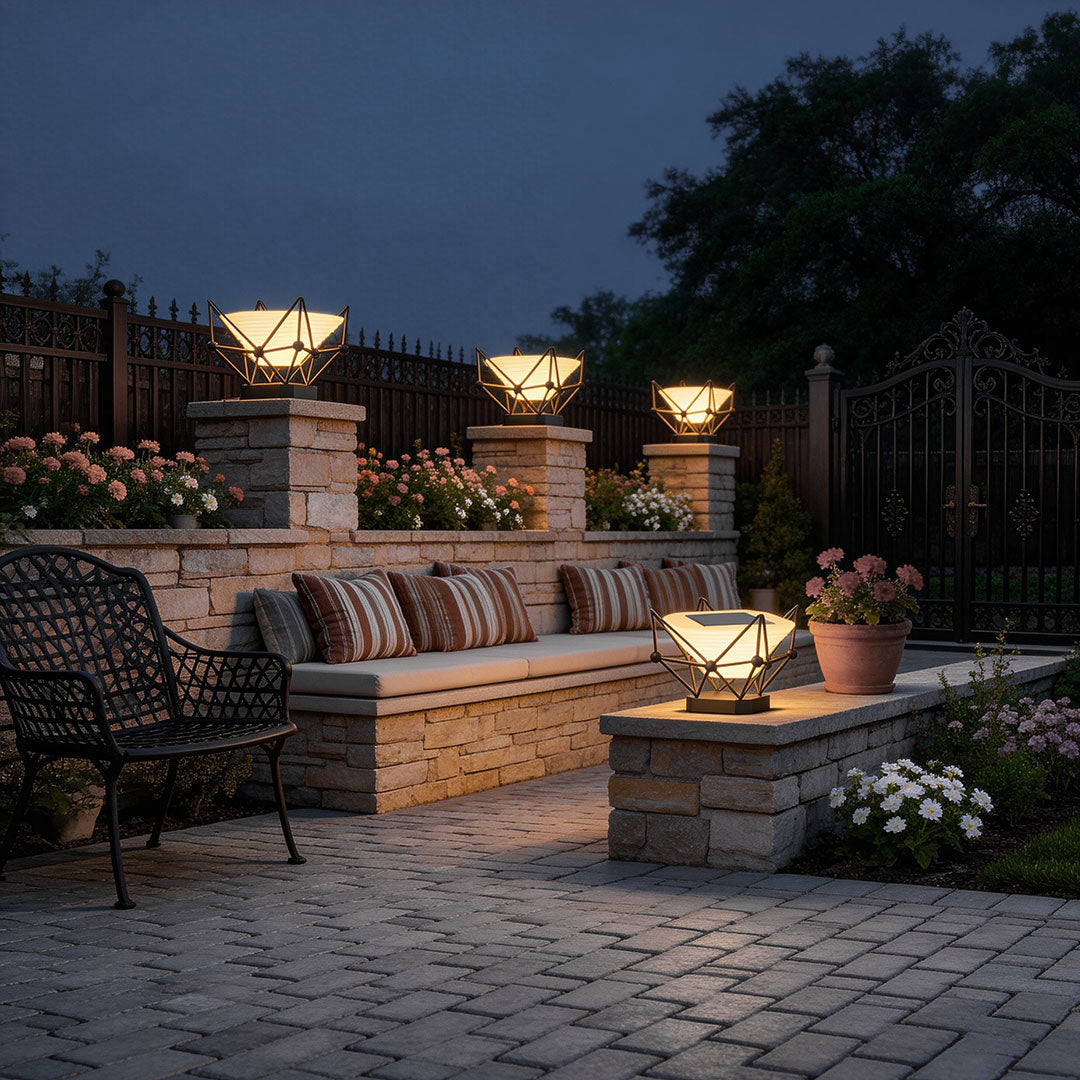 Modern pillar lights for garden illuminating a cozy patio with outdoor furniture and stone walls at dusk.