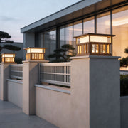 Modern pillar lights for house with a sleek design, installed on a stone fence near a contemporary building.
