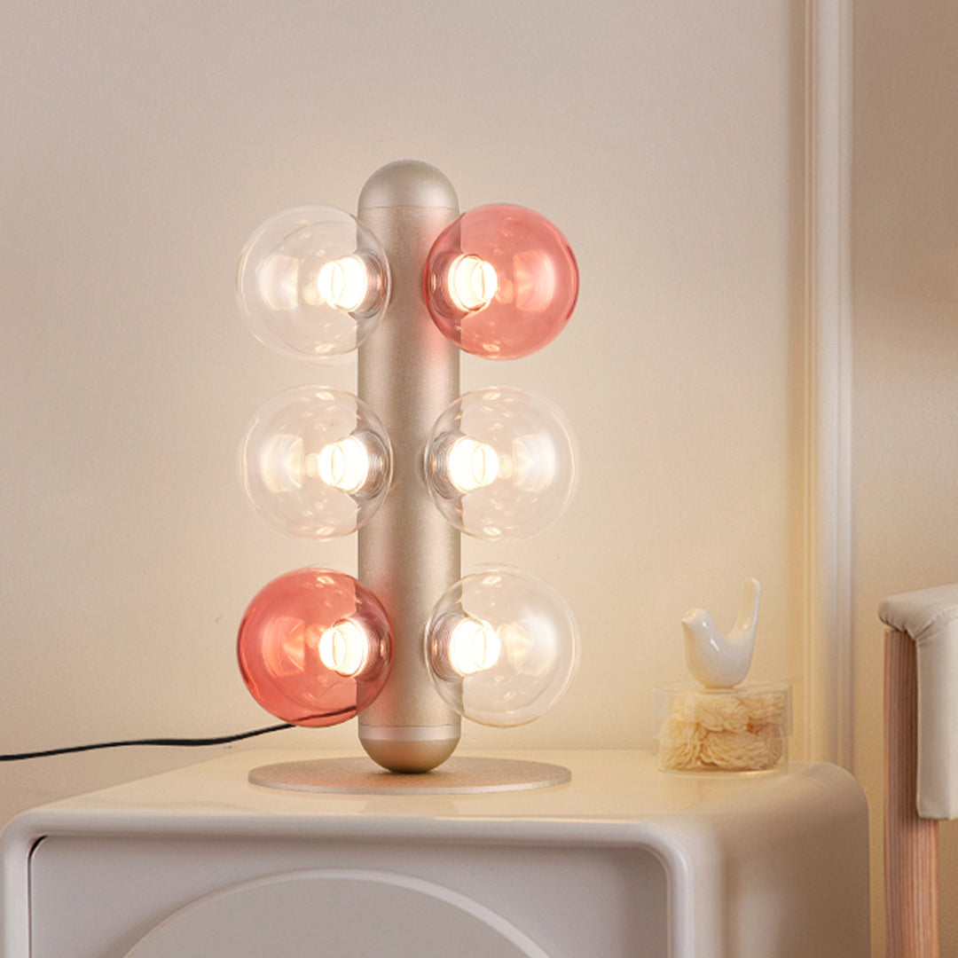 Modern bubble table lamp featuring pink and clear glass spheres with brass vertical support
