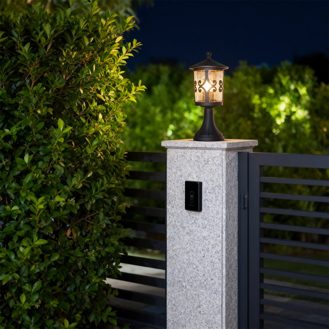 Modern porch pillar light brightening white concrete pillar beside contemporary black metal fence at night