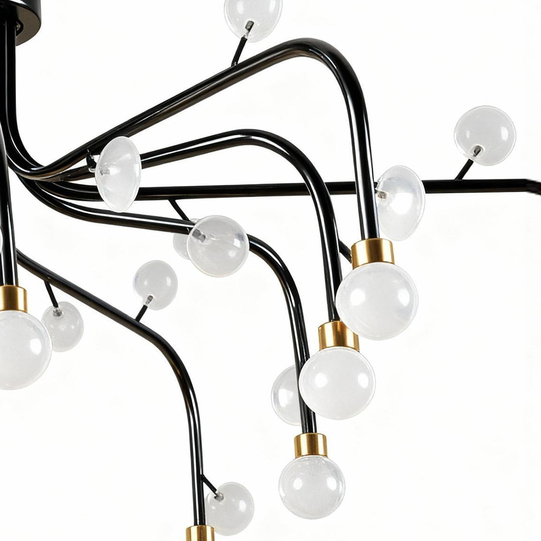 Close-up detail of modern retro chandelier showing branching black arms and white glass sphere construction