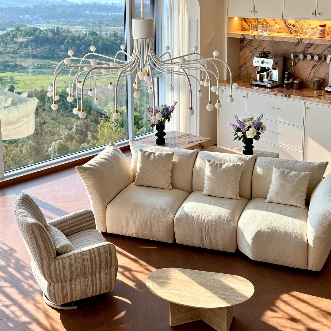 Modern retro chandelier as focal point in bright living room with cream sofas and panoramic window views