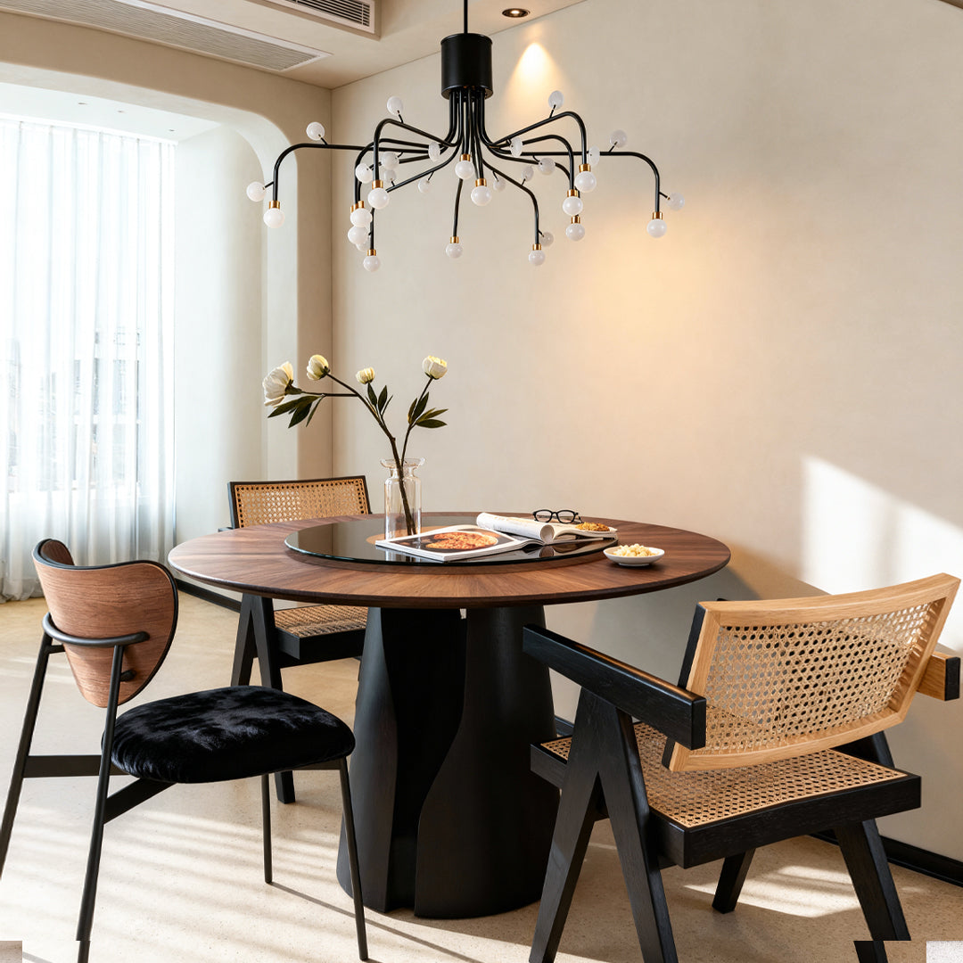 Modern retro chandelier hanging above wooden dining table in airy space with natural light and cane chairs