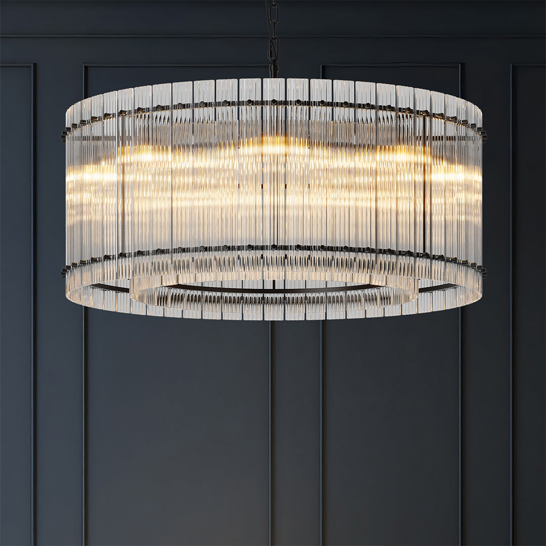 Modern round glass lamp shade chandelier with clear crystals and black frame hanging in elegant interior.