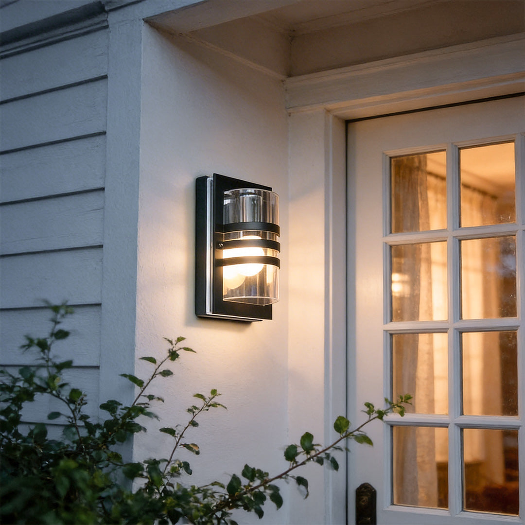 Modern sconces outdoor with a cylindrical design, mounted beside a white wooden window.