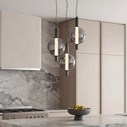 Sleek modern silver pendant light trio with smoked glass globes above a luxury marble kitchen.