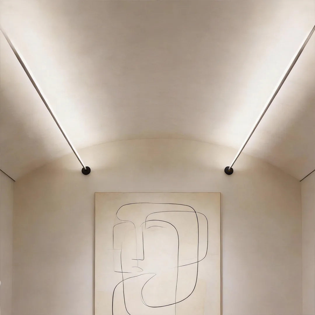 Modern skyline linear LED lighting mounted along a curved ceiling above wall art in a contemporary interior.