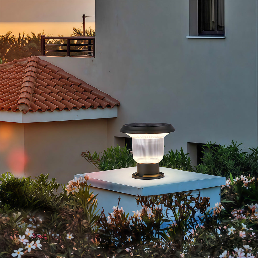 Modern solar pillar light providing clear illumination along a stone fence, enhancing the yard’s look.