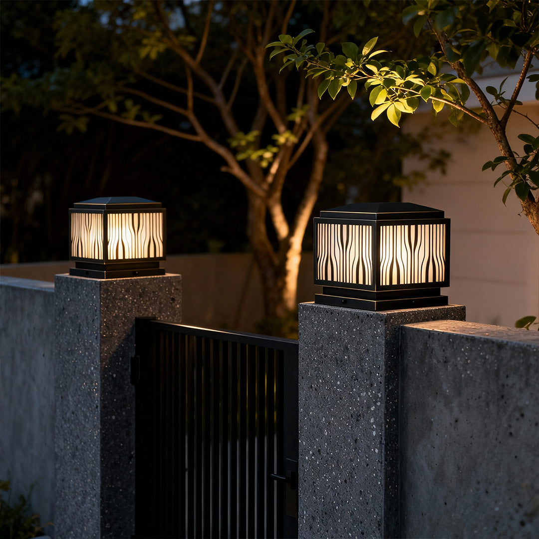Modern solar pillar lights mounted on a concrete pillar, providing soft illumination for a driveway.