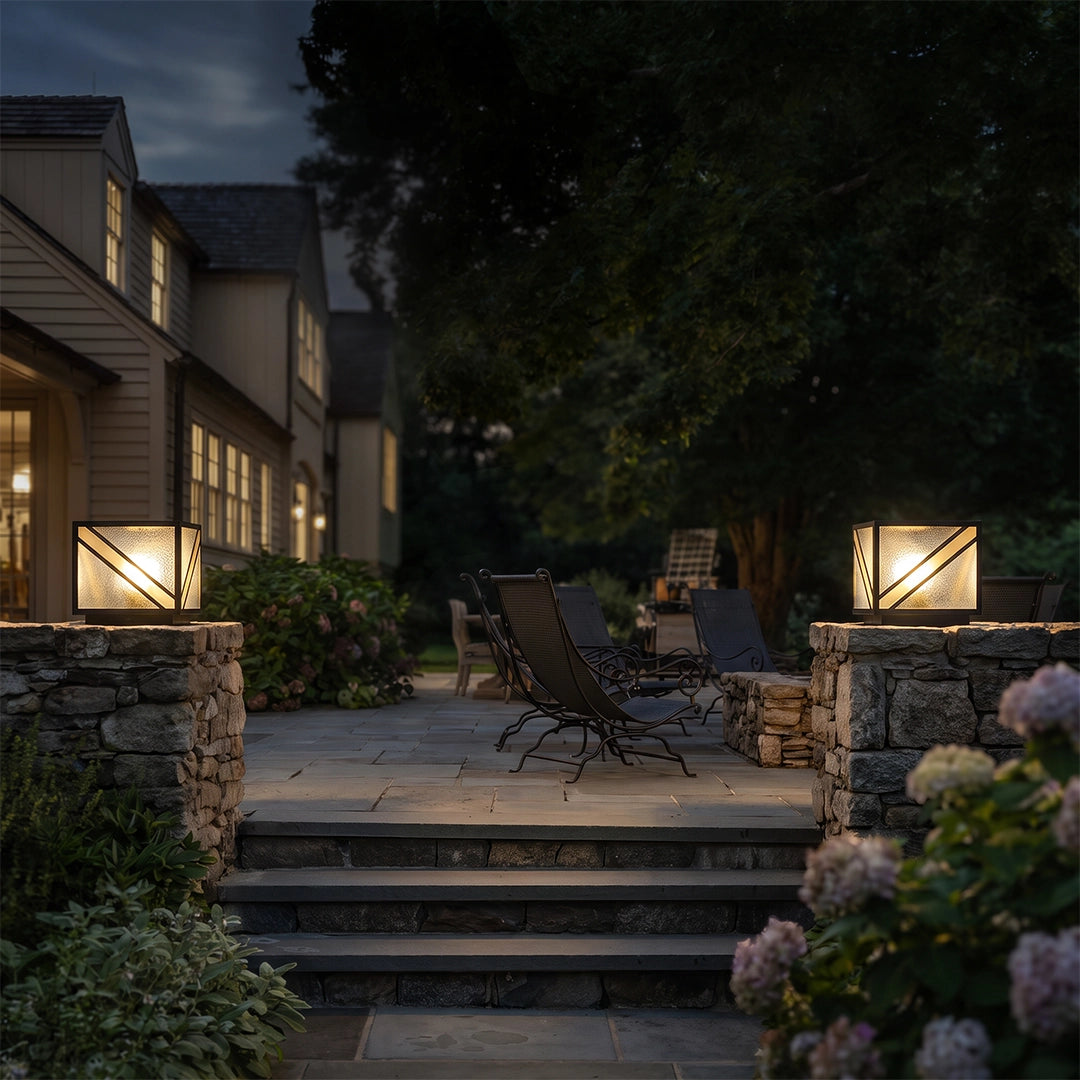 Modern solar pillar lights illuminating garden patio and stone columns at night