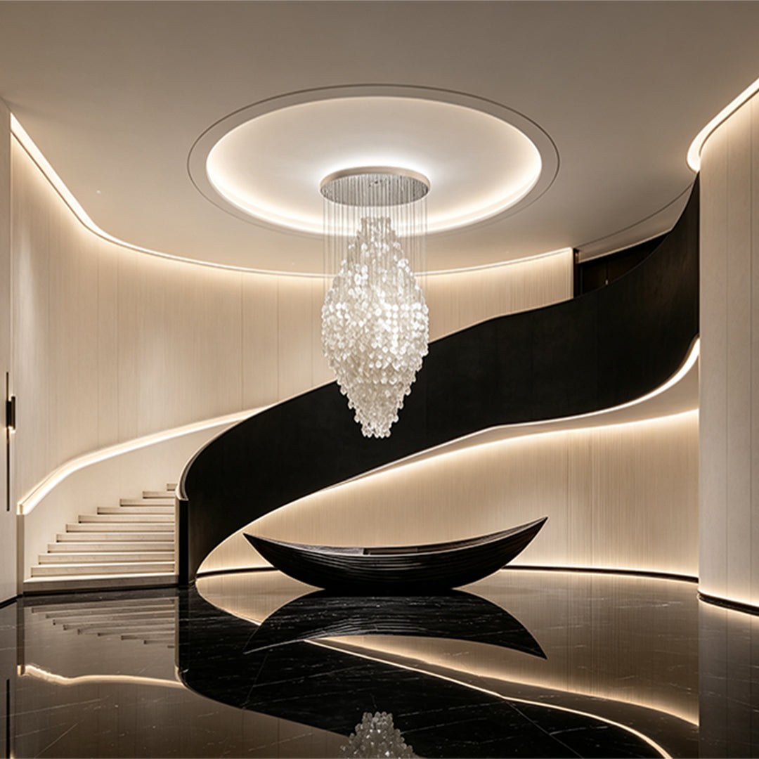 Modern staircase chandelier illuminating a curved staircase with a tall sculptural crystal form.