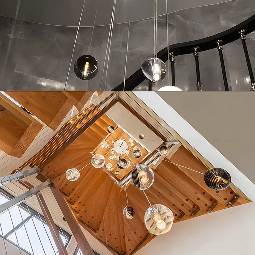 Modern staircase illuminated by metal pendant lights with smoked glass shades, creating a warm and inviting ambiance.