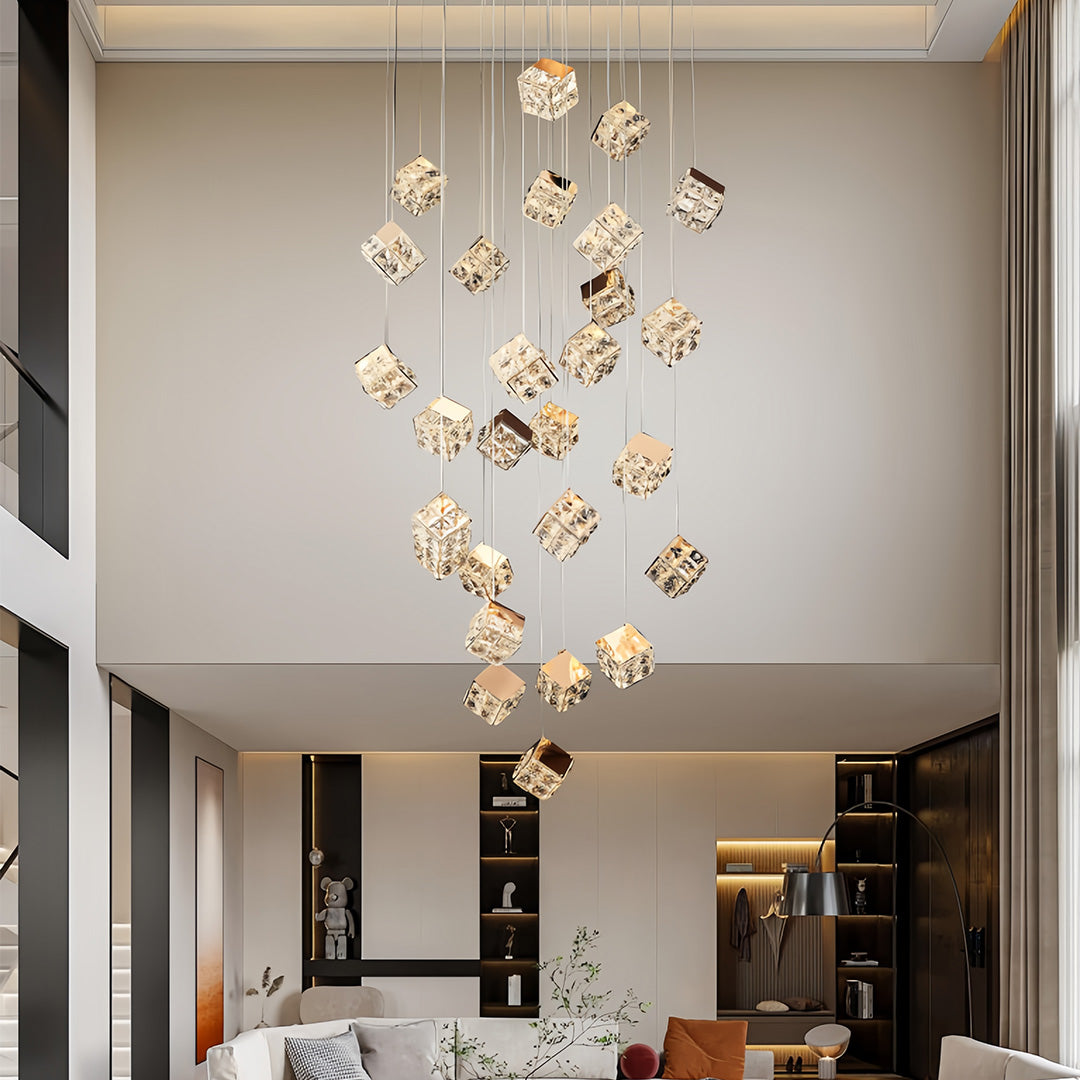 Large modern chandelier hanging above open staircase in double-height living room.