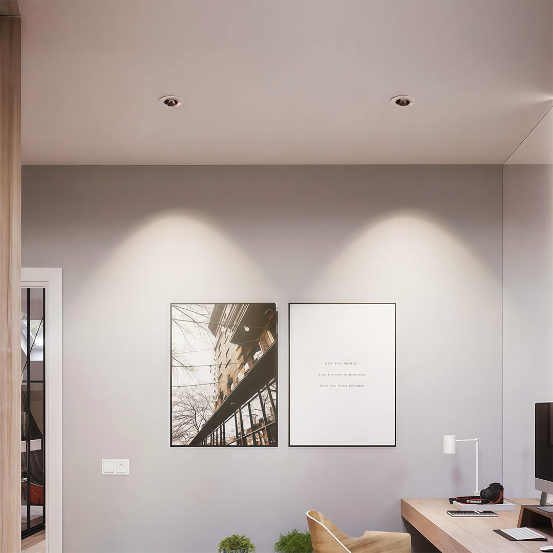 Modern study area featuring square recessed downlight fixtures illuminating two framed pictures on the wall.