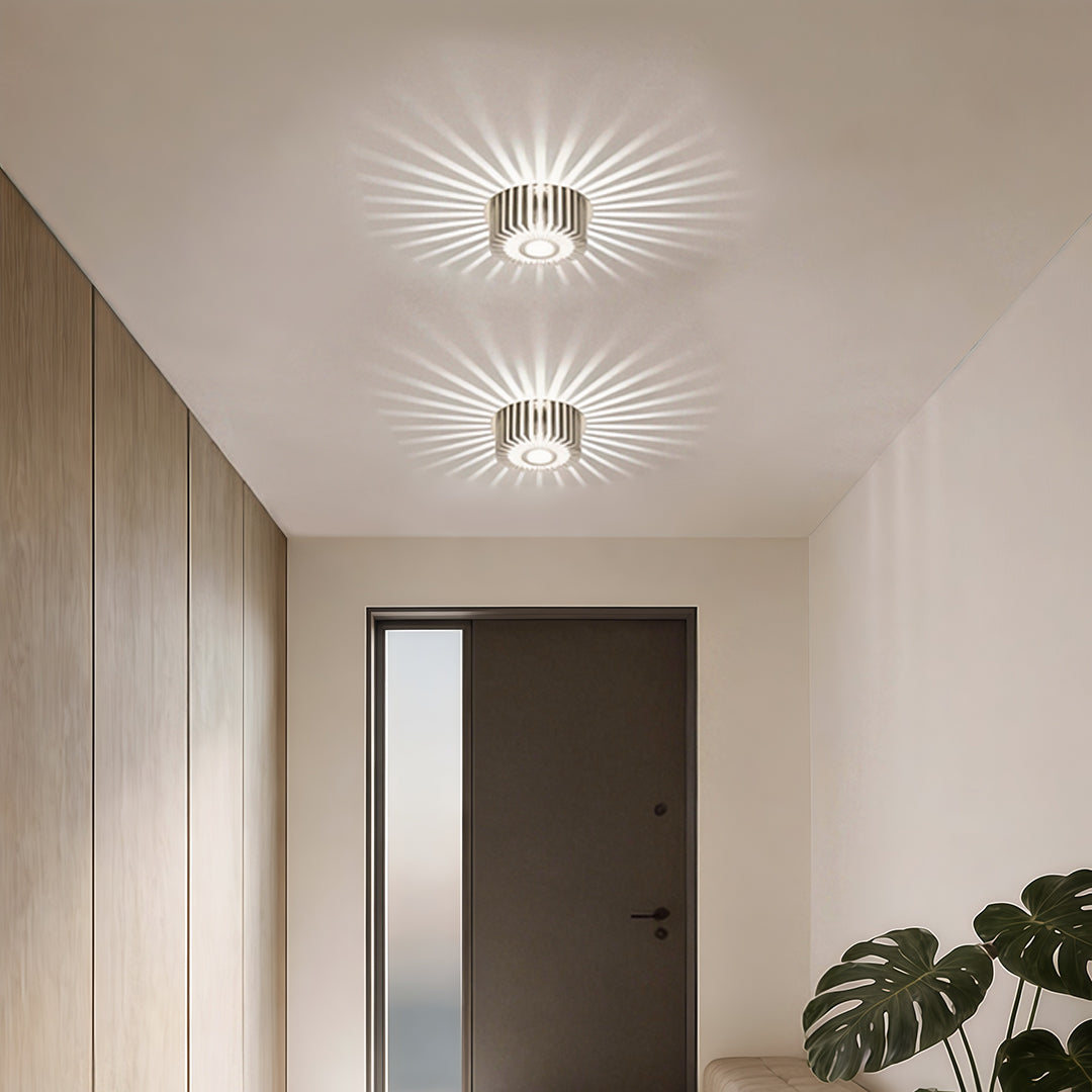 Modern sunburst ceiling fixture illuminating a hallway with warm, radiant glow. 