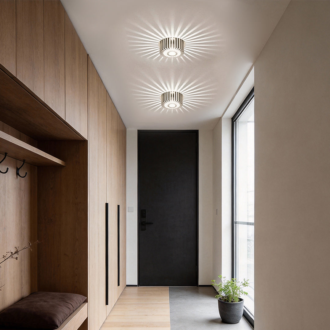 Modern sunburst ceiling fixture providing soft light in a contemporary corridor.